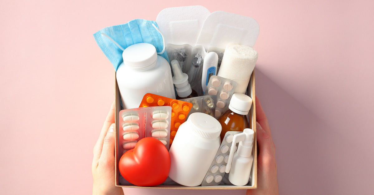 An overhead view of a box with first aid supplies. The supplies include medications, bandages, and other medical items.